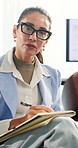 Woman, therapy and psychologist writing notes, listening and evaluation in counseling office for help. Psychology, mature person and notebook in consultation, support or mental health assessment