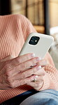 Hands, phone and relax with senior woman on sofa in home living room for social media browsing. App, text message and typing with elderly person in apartment for break, retirement or wellness