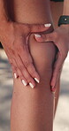 Fitness, exercise and person with hands on knee outdoor for injury, pain or muscle fatigue on run. Runner, woman and massage leg in nature for osteoporosis, arthiritis or joint problem on workout