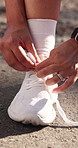 Fitness, hands and person tying shoes on road outdoor to start training, wellness and preparation. Sneakers, woman and runner with shoelace for sports practice, getting ready and health on street