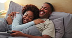 Laugh, watching tv and black couple on bed in home for comedy show, bonding or relax together. Happy, remote and man with woman in bedroom for streaming funny movie, film or series in apartment.