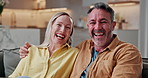 Face, couple and relax in home with laugh, funny story and love for bonding together on weekend. Happy, mature man and woman chill in living room with humor, good mood and romantic relationship.