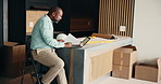 Laptop, black man and architect in office with paperwork for planning building, maintenance or repairs. Computer, typing and contractor with title deed documents for approval on home renovation.