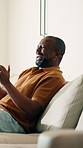 Man, applause and watching tv on sofa with sports game, goal celebration and football competition. Mature, black person clap and cheering in home with soccer broadcast, happy and excited for win.