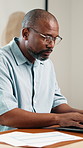 Man, documents and remote work in home office with laptop, review budget or finance administration. Freelancer, mature black person and typing with computer, glasses and paperwork for financial plan.