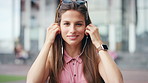 Face, commute and woman with earphones in city, happy or listen to music with subscription on street. Outdoor, portrait and person with smile, travel and streaming audio with technology in Brazil