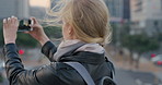 Travel, photo or woman in city with phone screen, online memory or sightseeing post on weekend break. Digital, wind or person with tech, social media update or cityscape capture on tourist trip.