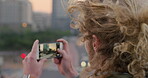 Travel, photo or man in town with phone screen, sightseeing memory or outdoor post on weekend break. Wind, back or person with tech, social media update or city skyline picture on tourist trip.