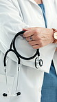 Doctor, hand and stethoscope for healthcare, cardiology and heart wellness in hospital. Woman, medical professional and pulmonary cardiologist with equipment for lung health, arms crossed and tools