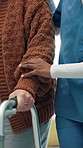 Hands, nurse and senior with walker in home for assisted living, healthcare or physiotherapy. People, caregiver and helping patient with walking aid for mobility, elderly care or rehabilitation