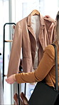 Rail, hanger and woman with clothes in store for fashion with choice, decision or shopping. Discount rack, sale and back of female person with jacket for luxury brand, outfit or clothing in boutique.