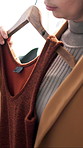 Rail, hanger and woman with top in store for fashion with choice, decision or shopping. Discount rack, sale and female person with clothes for luxury brand, outfit or option with style in boutique.