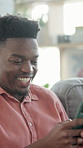 Reading, scroll or black man with phone on couch, social media notification or typing message for chat. Smile, internet or person with tech for texting, check forum post or video comments in home