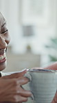Woman, laughing and couple in home with coffee, start day and calm morning in living room. Smile, African people and relax at house with beverage, funny discussion and comfortable for weekend break