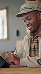 Happy, scroll and black man on tablet in coffee shop for research, online article and remote work. Stylist, freelancer and person on digital tech for fashion blog, content creation and review in cafe