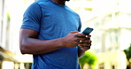 Phone, fitness and hands of man in city with typing for texting, social media or chatting. Athlete, technology and male person scrolling on app for workout program on cellphone in urban town.