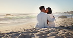 Hug, black couple and kiss on holiday at beach for anniversary getaway, bonding and connection. Back, love and happy people with affection on sand for romantic vacation, trust or healthy relationship
