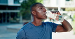 City, black man and fitness with water for drinking, hydration and liquid beverage for workout break. Training, male person or rest with bottle for mineral H2O, thirst or wellness for exercise