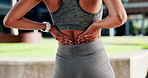 Woman, fitness and hands with back pain for workout accident, strain or outdoor exercise in city. Active, female person or training with sore spine for muscle tension or fibromyalgia in an urban town