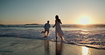 Beach, playful and couple with splash at sunset for bonding on vacation, holiday and travel together. Dating, sea and man with woman for relationship, connection or playing in waves on summer weekend