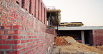 Construction, architecture and empty building at site, brick wall and concrete for engineering. Development, scaffolding and exterior with incomplete infrastructure, dirt and framework design