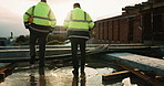 Construction, done or people on site with walking, progress conversation or bonding in job completion. Teamwork, back or engineers with flare, project perspective or shared satisfaction at end of day