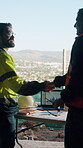 Architect, handshake and men with laptop screen at construction site, team and property development. Civil engineer, discussion and shaking hands for project data, graphs and happy people with tech