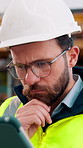 Engineer, man and thinking at construction site with tablet, check building design or risk assessment. Person, reading and problem solving outdoor with tech, glasses or review for engineering project