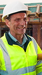 Engineer, man and talk at construction site with smile, planning and good news for building project. Happy, mature person and discussion outdoor with PPE, infrastructure and engineering feedback.