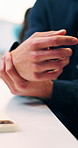 Person, hands and phone with wrist pain or injury in office for arthritis, discomfort or strain. Closeup, employee or sore arm on smartphone for muscle tension, carpal tunnel syndrome or fibromyalgia