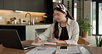 Student, writing and Asian woman in home with laptop, notebook and online education for university. Person, reading and study notes in house with computer, elearning and college research assignment.