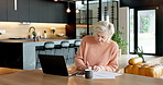 Senior, woman and finance with documents in home for budget planning or expenses on laptop. Elderly, female person or writing with papers or computer for financial report or asset management in house