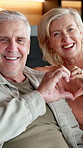 Smile, face and senior couple with heart hands in living room for love, bonding and relax in home. Portrait, elderly woman and man together in retirement for commitment, support and marriage in house
