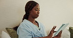 Black woman, relax and reading in bedroom with tablet, research or browsing website for bedtime. Female person, rest and closing at house with tech, social media and download ebook for weekend break