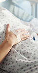 Patient, hands and bed with drip in hospital for medical treatment, remedy or clinic recovery. Person, healthcare or rest with IV medicine, supplement or fluids for nutrition, life support or ICU