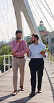 Business, people and walk on bridge with tablet, urban development proposal or real estate discussion. Realtor team, talk and outdoor in city with tech, property investment planning or collaboration.