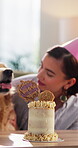 Stroke, girl and dog in home with birthday cake, bonding and celebration for adoption milestone. Pet owner, love and golden retriever in lounge to develop trust, animal care and treat at party