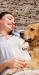 Woman, dog and relax in living room with smile, bonding together and sleepy pet rest on weekend break. Above, person and Golden Retriever puppy lay down in home with companion, love and tired animal.