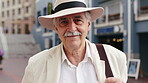 Hat, smile and face of old man in city for explore, peace and heritage specialist. Happiness, confidence and culture tour guide with senior person outdoor for traveler, tourism and weekend break