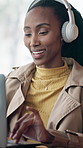Happy, laptop or black woman with headphones in cafe for music, podcast or remote work. Female person, freelancer or listening with smile on computer for audio streaming or network connection in shop