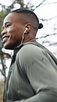 Athlete, man or running with earphones at park for exercise, pace training or music playlist. Fitness, happy black person or workout outdoor with audio streaming, sport performance or jogging routine