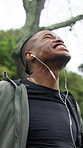 Exercise, man or excited with celebration at park for workout pace, performance or fitness goals. Earphones, black person and fist pump outdoor for cardio achievement, wellness target and improvement