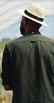 Black man, farmer and face in greenhouse with basket, back and hat with organic produce in summer. African person, vegetables and farming with inspection, harvest and agriculture with sustainability