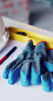 Gloves, construction and blueprint on table with safety documents, architecture or building design. Floor plan, paperwork and helmet for ppe, equipment and tools for infrastructure development
