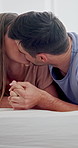 Couple, kiss and holding hands on bed, support and bonding with partner on break or laugh in bedroom. Love, connection and affection for spouse, talking and happy people on weekend and relax in house