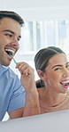 Mirror, couple and brushing teeth for dental wellness, oral hygiene and morning routine in bathroom. Happy man, woman or cleaning with toothbrush at home for fresh breath, gum care or mouth health