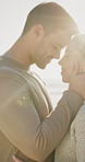 Love, travel and couple with smile on beach for romance, date and anniversary vacation or bonding together. Sunset, trip and happy people with affection for weekend holiday, loyalty and support