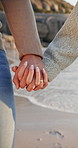 Love, travel and couple holding hands on beach for romance, date and vacation or bonding together. Sunset, walk and happy people with affection for weekend holiday, loyalty and anniversary support