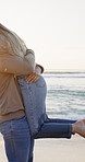 Love, travel and couple with hug on beach for romance, date and anniversary vacation or bonding together. Sunset, excited and playful people with kiss for weekend holiday, loyalty and support