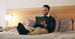 Businessman, relax or hotel with tablet in bedroom for business network, social media or schedule. Happy man, employee or traveler with smile on technology for internet, connection or browsing in bed